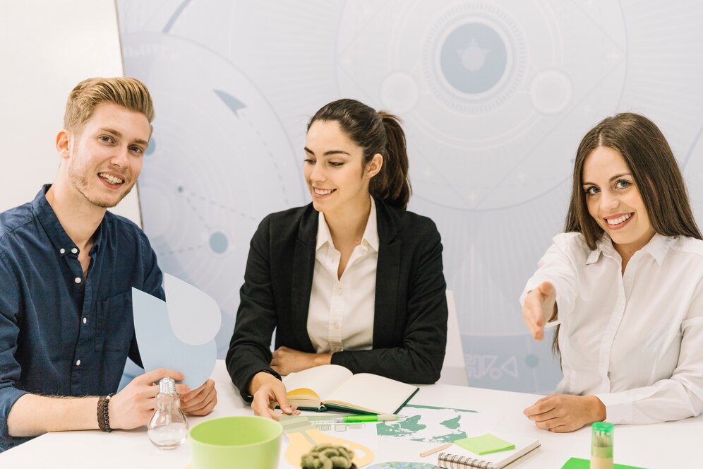 Three business professionals engaged in a meeting with documents and coffee cups.