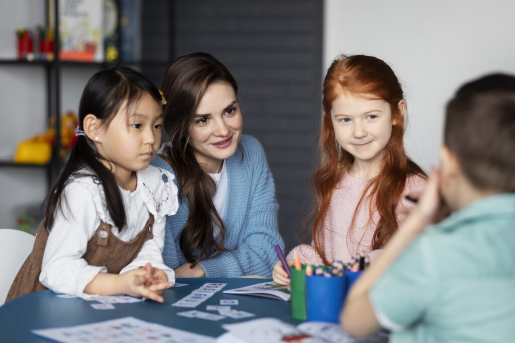 A teacher engaging with young students in a classroom.