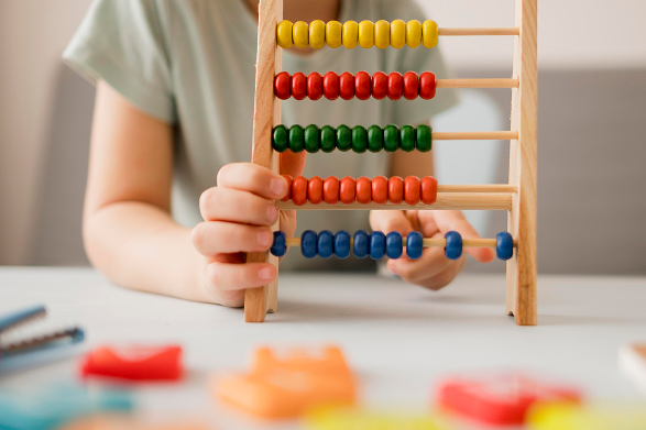 Child using a colorful abacus for counting.
