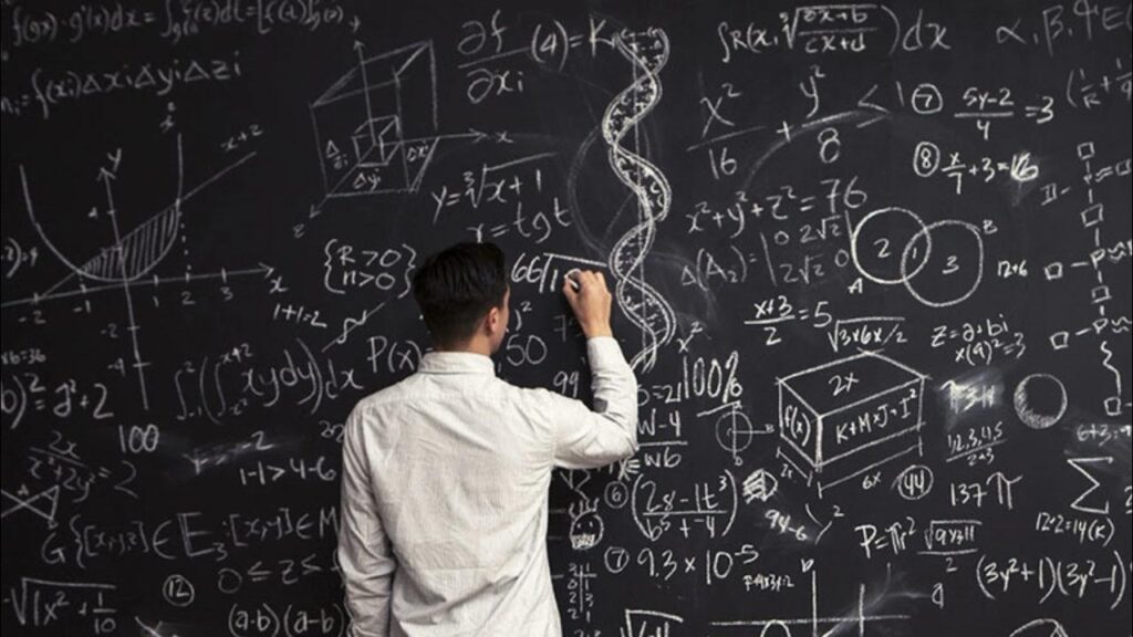 A man solving complex math equations on a blackboard.